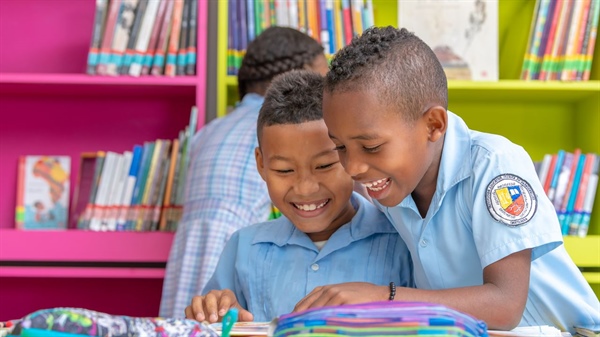 Imagen de niños estudiando y riénsose